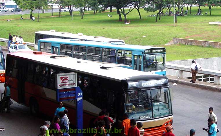 Motoristas e cobradores de ônibus descansando à sombra das árvores em torno da plataforma Rodoviária de Brasília