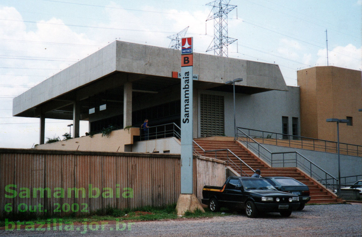 Fachada e acesso sul à Estação Samambaia do Metrô DF, com 2 lances de escada, devido ao terreno mais alto. À direita, o início e o final dos 2 lances da rampa para acessibilidade de cadeirantes e pessoas com outras dificuldades de locomoção